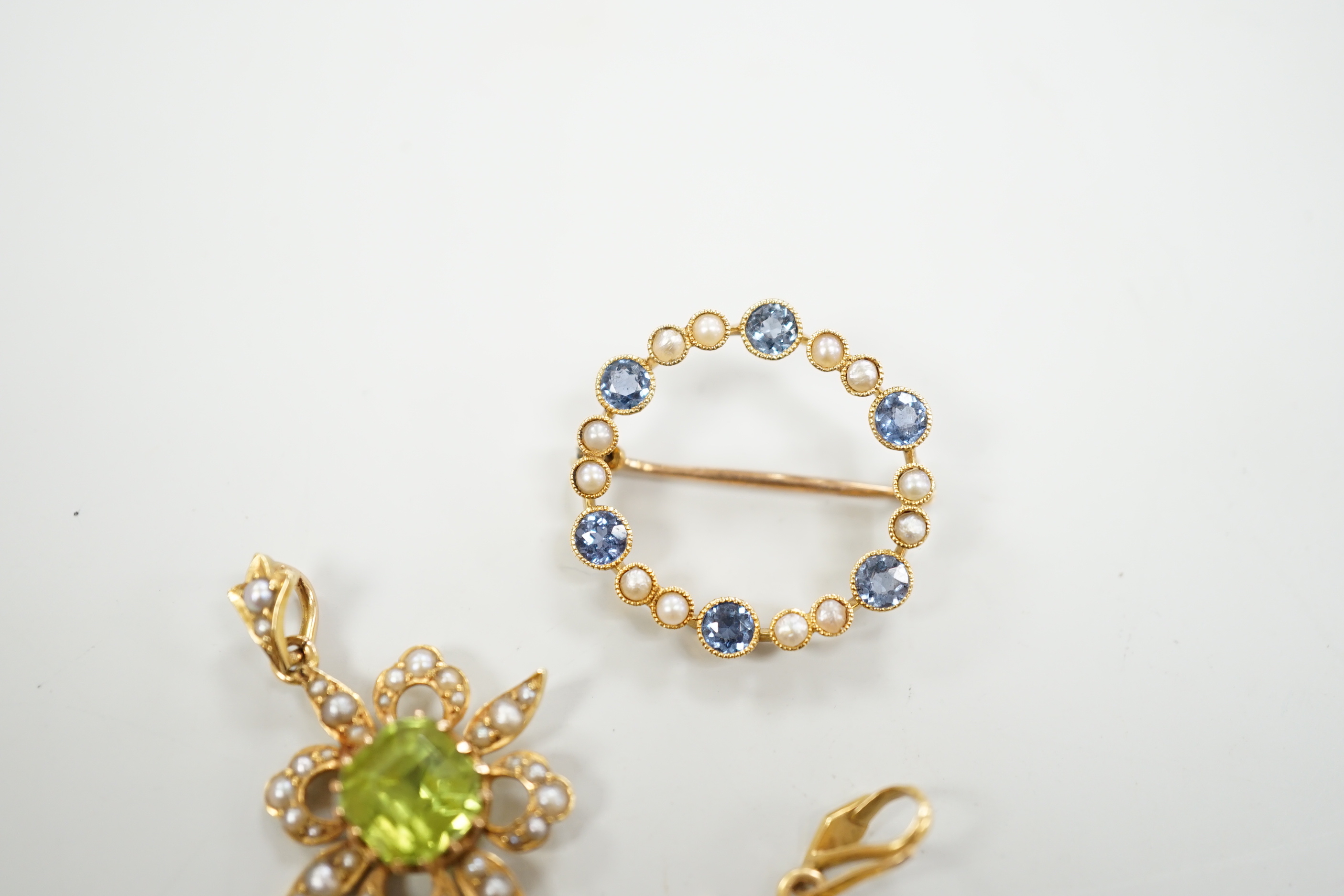 Two Edwardian 15ct and gem set pendants including peridot and seed pearl, 27mm and a similar 15ct and gem set open work circular brooch, gross weight 7 grams.